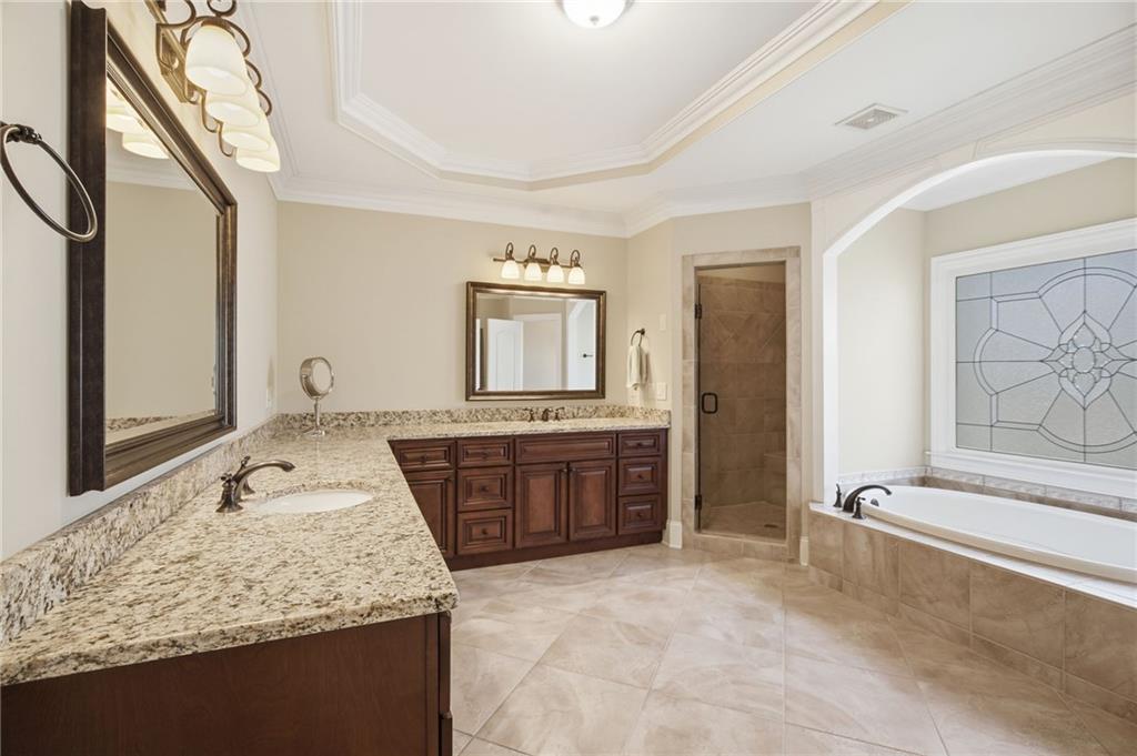 715 Crown Cove Milton, GA 30004 - Photo 33 of 102 a bathroom with a granite countertop sink and mirror with bathtub