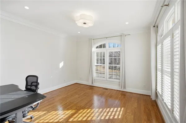 a kitchen with stainless steel appliances granite countertop a sink a oven a dining table and chairs with wooden floor