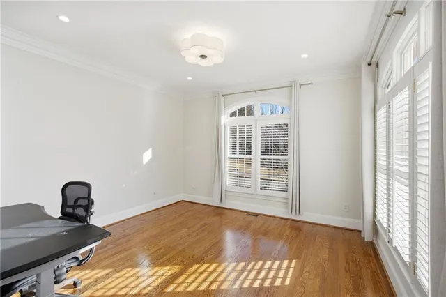 a kitchen with stainless steel appliances granite countertop a sink a oven a dining table and chairs with wooden floor