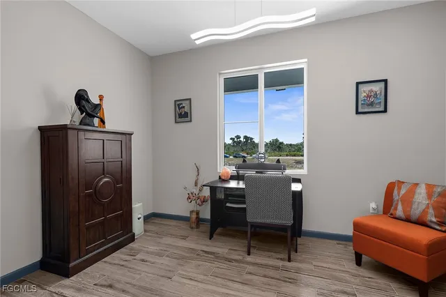 a open kitchen with stainless steel appliances granite countertop a stove a refrigerator a oven a dining table and chairs with wooden floor