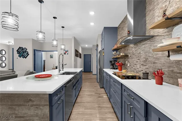 a kitchen with stainless steel appliances a table chairs and chandelier