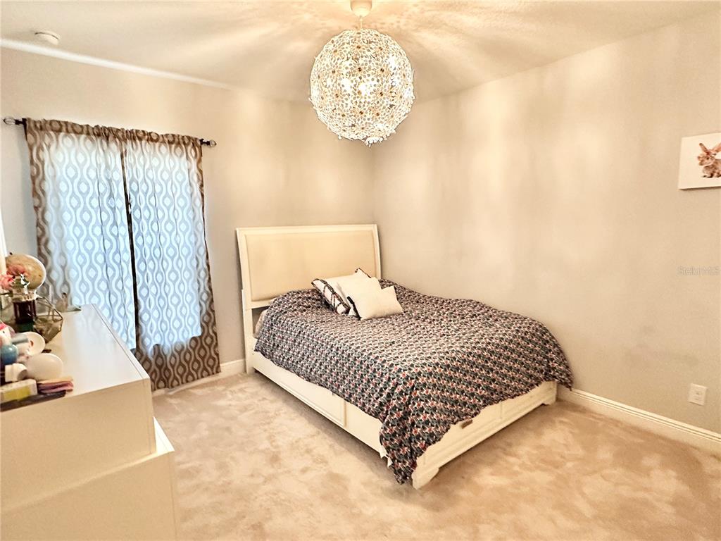 207 Petosky Road Groveland, FL 34736 - Photo 14 of 21 a bedroom with a bed and a chandelier