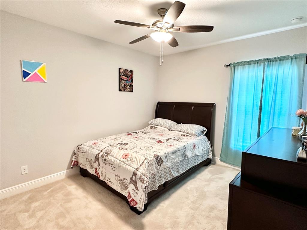 207 Petosky Road Groveland, FL 34736 - Photo 15 of 21 a bedroom with a bed and a chandelier