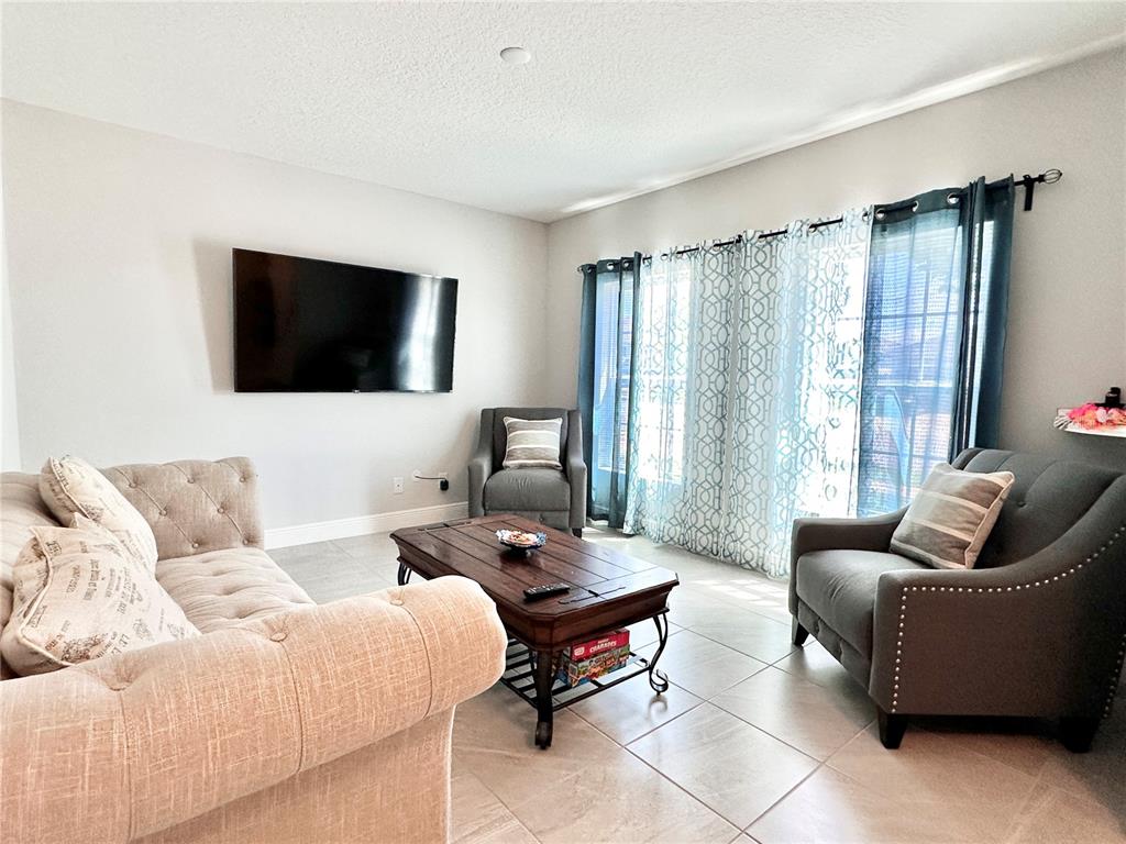 207 Petosky Road Groveland, FL 34736 - Photo 2 of 21 a living room with furniture and a flat screen tv