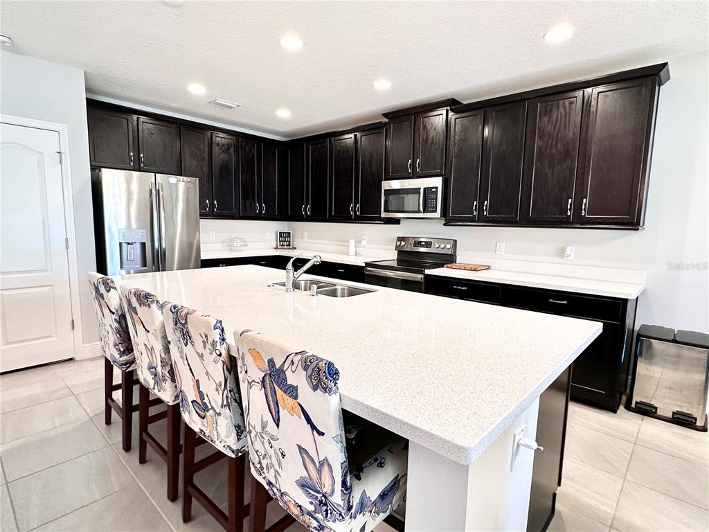 207 Petosky Road Groveland, FL 34736 - Photo 3 of 21 a kitchen with kitchen island cabinets and refrigerator