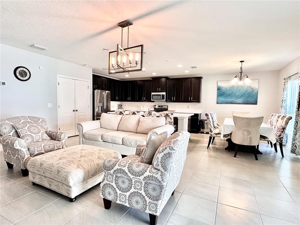 207 Petosky Road Groveland, FL 34736 - Photo 8 of 21 a living room with furniture a flat screen tv and kitchen view
