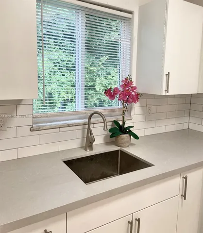 a view of a kitchen sink a counter space and cabinets