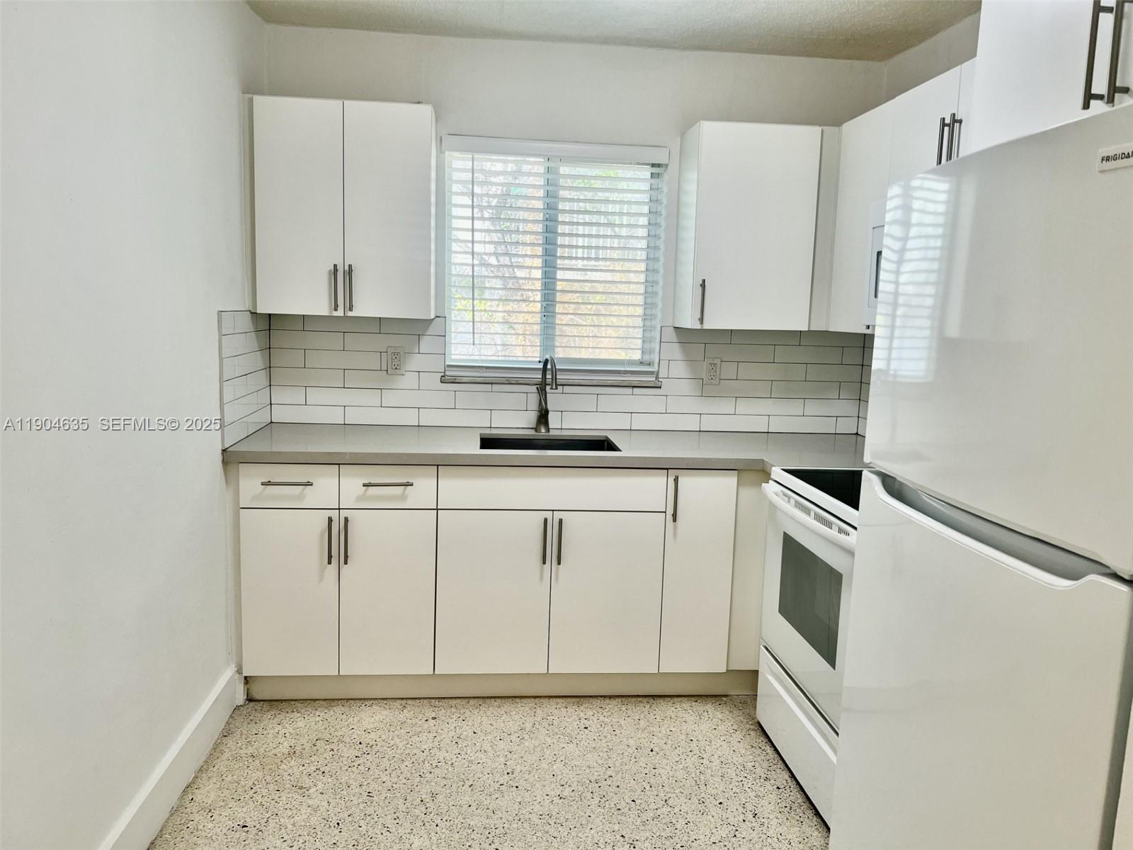 1012 Southwest 4th Avenue, Unit 3 Miami, FL 33130 - Photo 3 of 16 a kitchen with white cabinets and white appliances