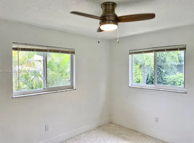 a view of empty room with window ceiling fan and window