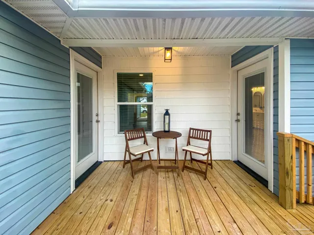 a view of a patio with table and chairs with wooden floor and fence