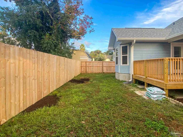 a view of a house with backyard and sitting area