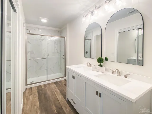 a bathroom with a double vanity sink mirror and
