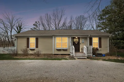 a front view of a house with basket ball court and wooden fence