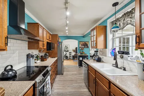 a kitchen with counter top space a sink stove and cabinets