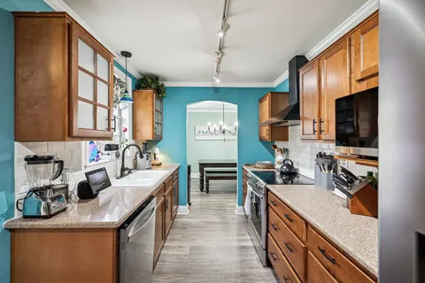 a kitchen with stainless steel appliances granite countertop a sink stove and refrigerator
