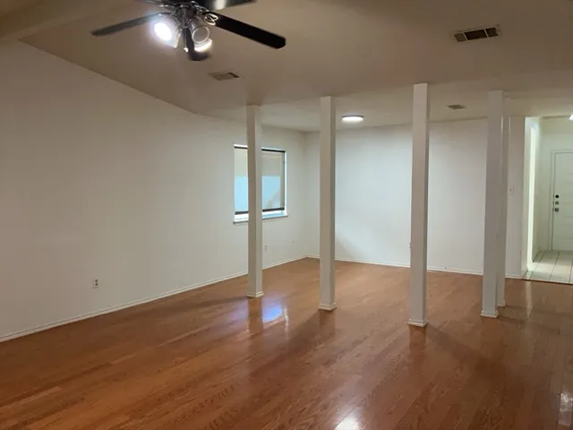 a view of an empty room with wooden floor