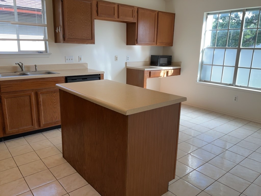6005 Avery Island Avenue Austin, TX 78727 - Photo 7 of 20 a kitchen with stainless steel appliances a sink stove and a refrigerator