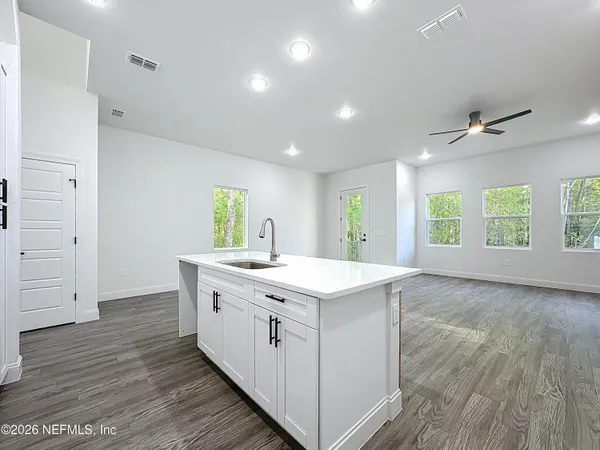 a view of kitchen with kitchen island stainless steel appliances cabinets and wooden floor