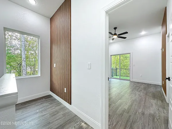 wooden floor in an empty room with a ceiling fan