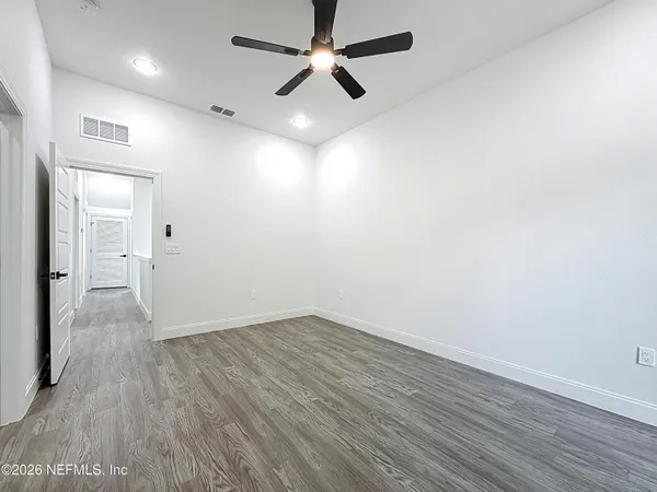 a view of empty room with wooden floor and window