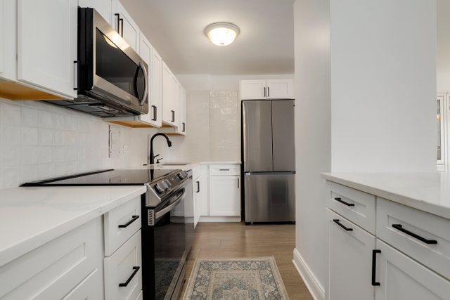 5701 North Sheridan Road, Unit 4R Chicago, IL 60660 - Photo 7 of 18 a kitchen with stainless steel appliances a refrigerator stove and microwave