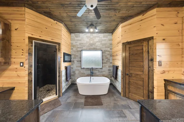a bathroom with a tub sink and mirror