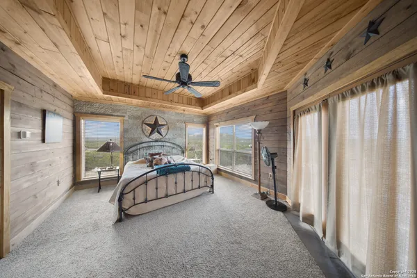 a bedroom with a bed and large windows