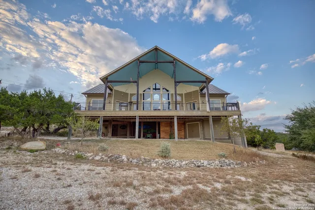an aerial view of residential houses with outdoor space and trees