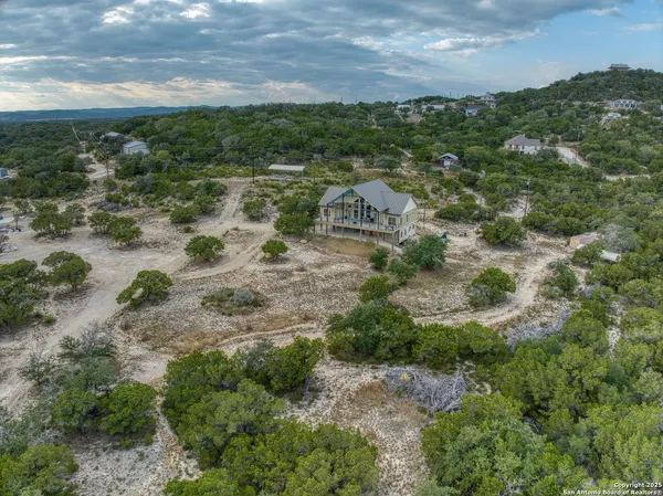 an aerial view of residential houses with outdoor space and trees