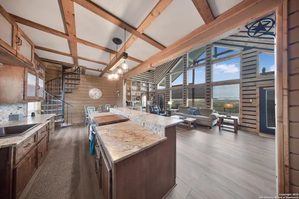 a view of a kitchen with kitchen island a counter space a sink and wooden cabinets