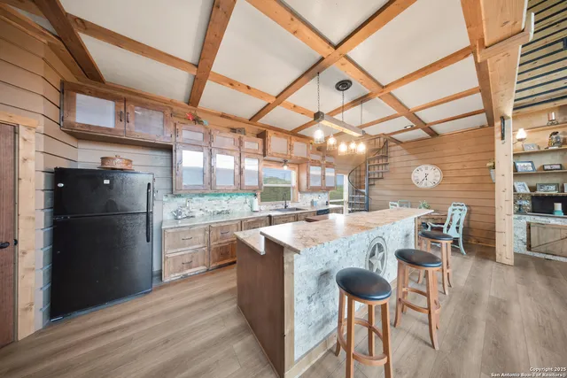 a kitchen with stainless steel appliances granite countertop a refrigerator a stove and a wooden floors