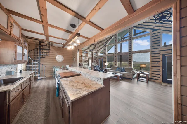 a view of a kitchen with kitchen island a counter space a sink and wooden cabinets