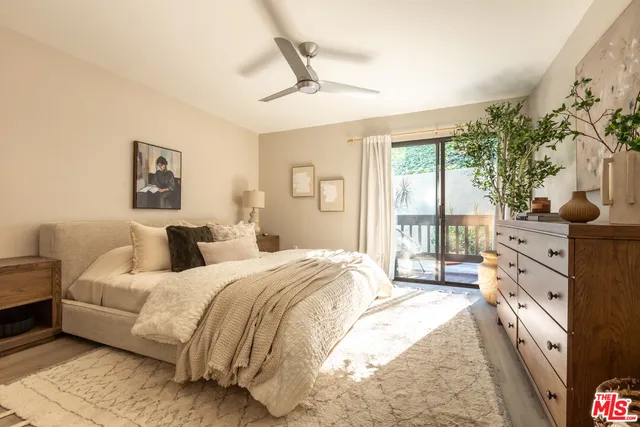a bedroom with a large bed and a flat tv screen