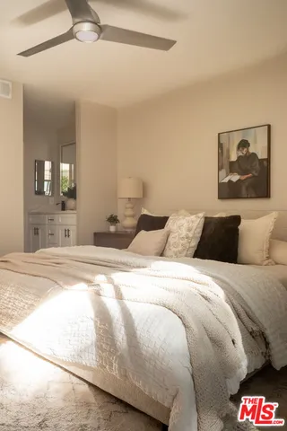 a spacious bedroom with a bed and lamp