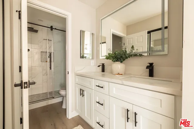 a bathroom with a shower sink and mirror