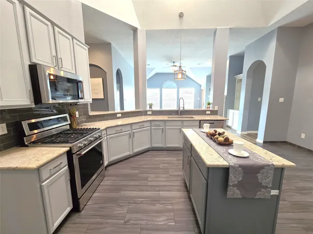 a kitchen with stainless steel appliances granite countertop a stove a sink dishwasher and a refrigerator