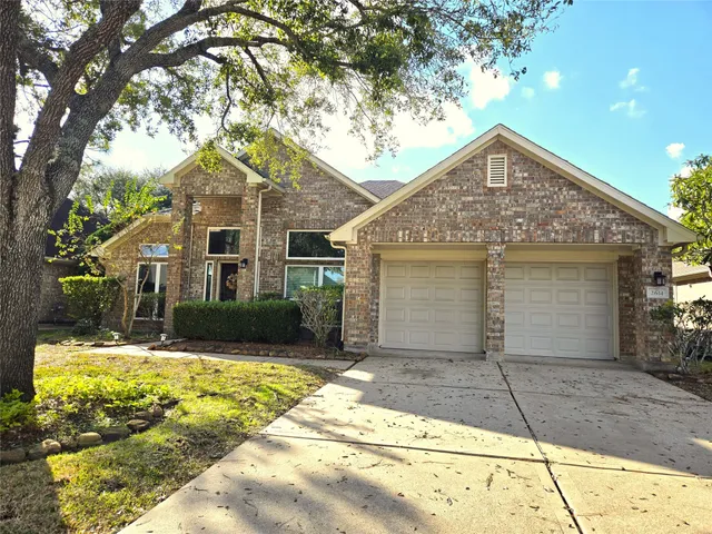 a front view of a house with a yard and potted plants
