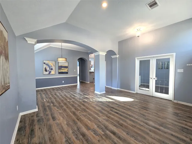 a view of a hallway with wooden floor and a living room