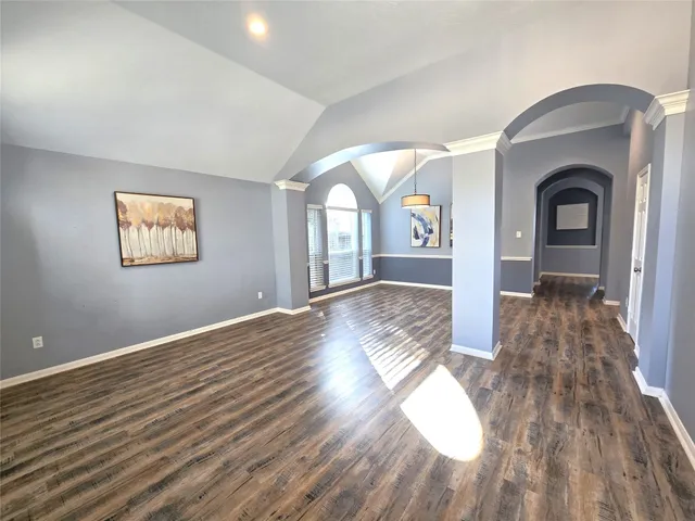 a view of empty room with wooden floor and window