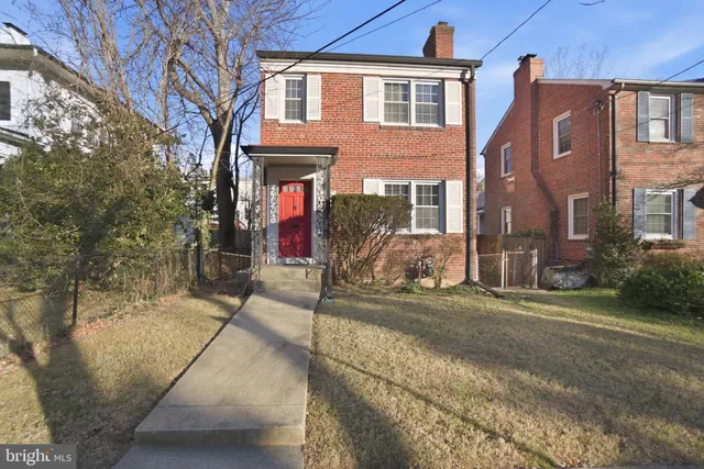 a view of a brick house with many windows next to a road