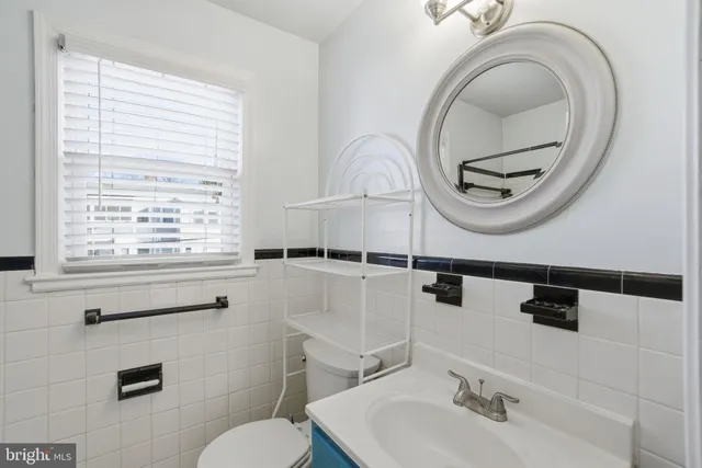 a bathroom with a toilet a sink and a mirror