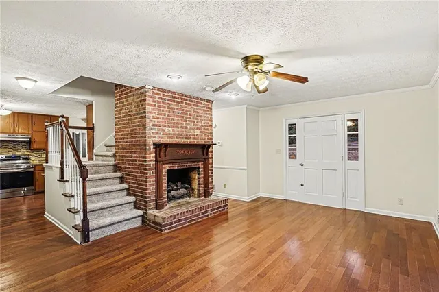 a view of a livingroom with wooden floor and a ceiling fan