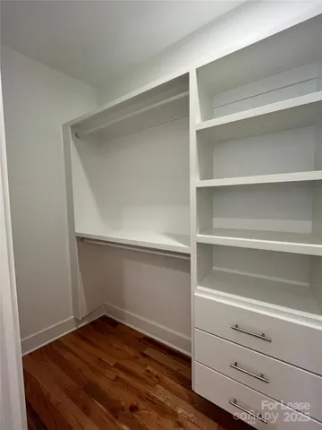 a view of walk in closet with empty racks