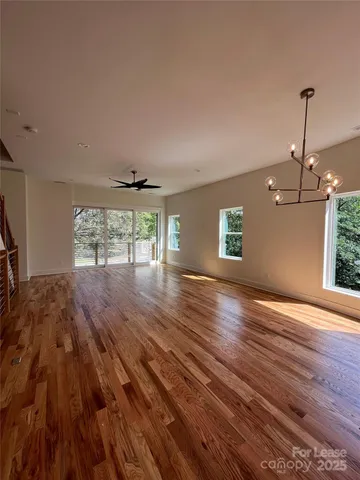 a view of a living room and kitchen with wooden floor