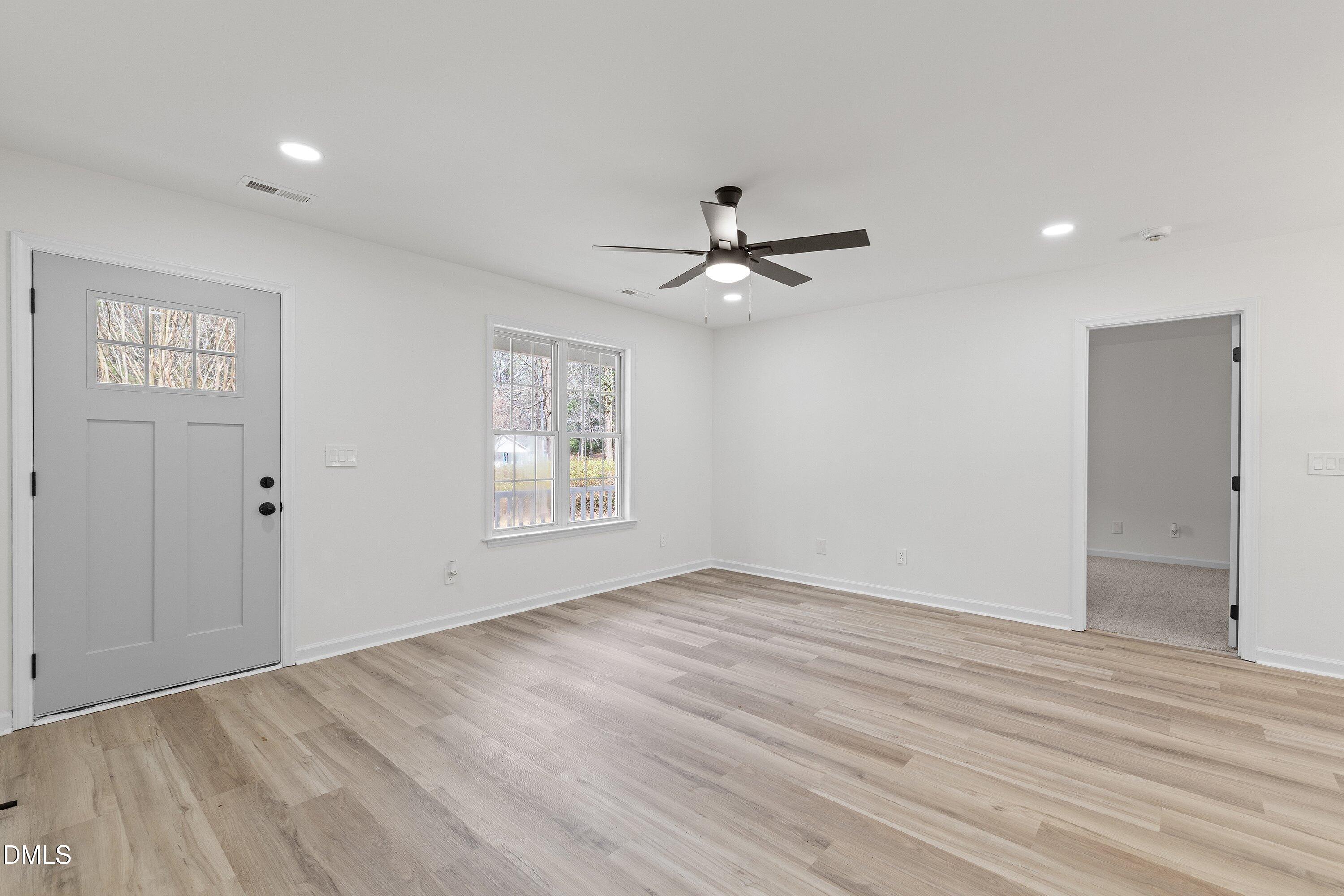 103 Callaway Lane Selma, NC 27576 - Photo 19 of 43 a view of an empty room with wooden floor and a window