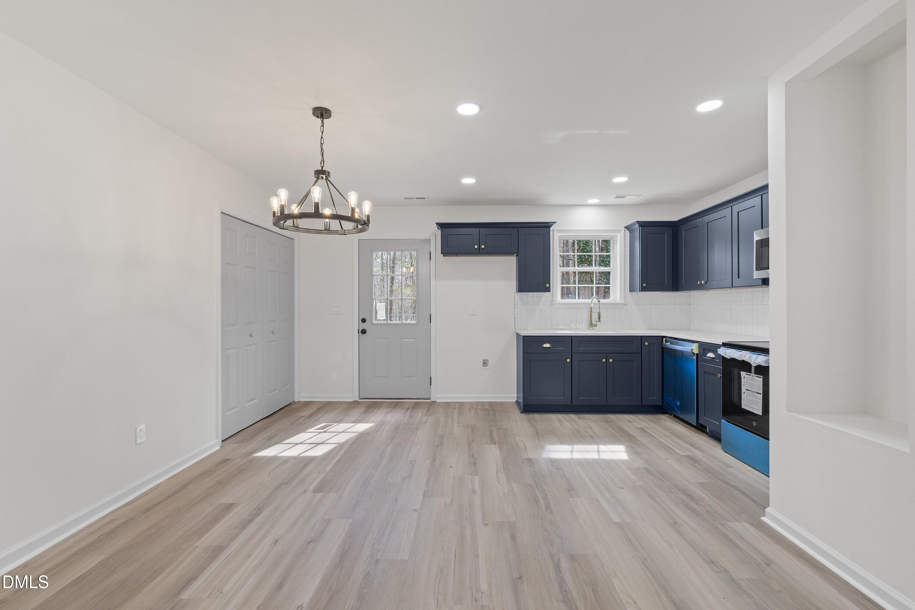 103 Callaway Lane Selma, NC 27576 - Photo 10 of 43 a open kitchen with kitchen island a refrigerator stove a sink dishwasher and a oven with wooden floor