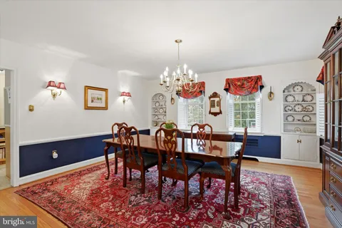 a kitchen with stainless steel appliances granite countertop a refrigerator a stove a sink and a dining table with wooden cabinet