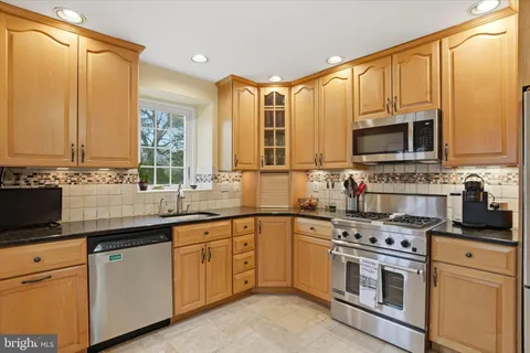 a kitchen with a refrigerator and a stove top oven