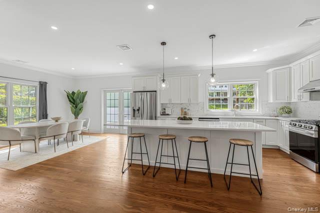 1 Kewanee Road New Rochelle, NY 10804 - Photo 14 of 36 a kitchen with stainless steel appliances granite countertop a stove a sink a window and chairs