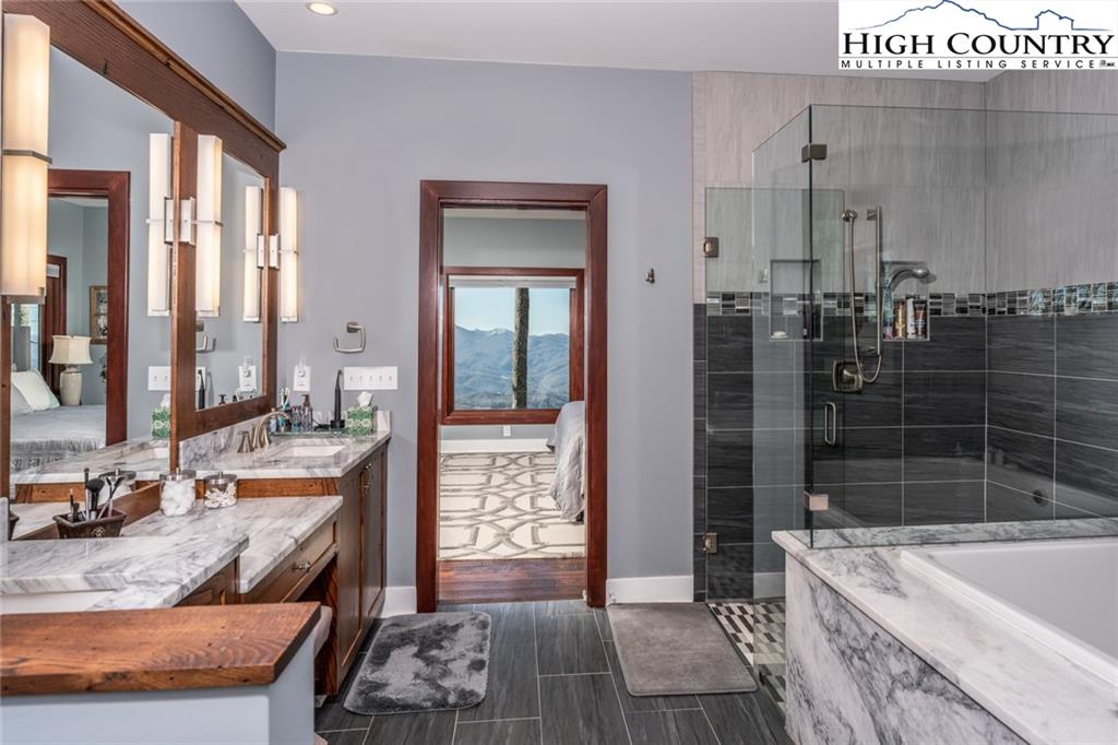 756 Saddle Road Vilas, NC 28692 - Photo 14 of 32 a large bathroom with a tub a double vanity sink a mirror and shower